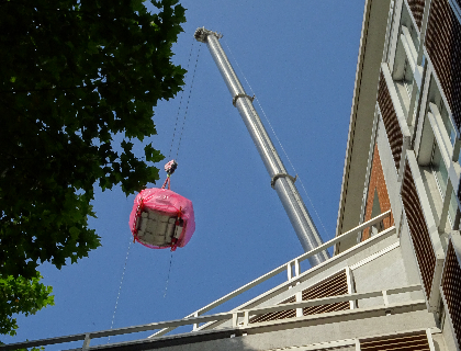 A high rise crane carefully lowering the multi-million pound 3T MRI scanner through the hospital’s roof.